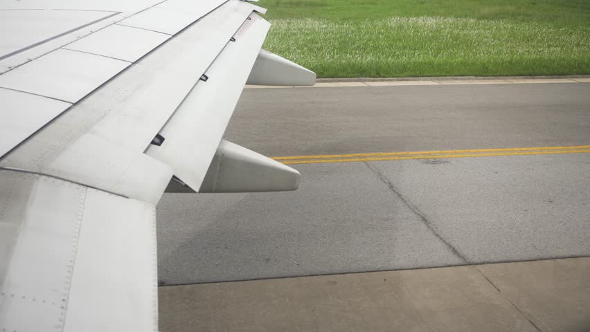 Wing of an Aircraft landing at Airport Phuket, Thailand Aircraft wings inboard aileron lifting up for maneuvering speed while landing at the airport