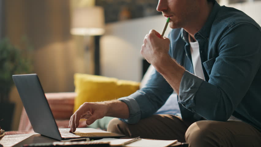 Loving wife bringing coffee to serious husband working at laptop close up. Smiling young woman seat down near busy man on couch living room. Guy freelancer enjoy break with cheerful girlfriend at home