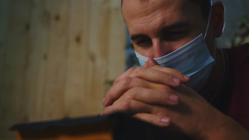 Asian man praying holy book with arms crossed. Man home during pandemic wearing medical mask of protection. safety on face. Man prays for health with hope. Medical mask protect against pandemic virus Royalty-Free Stock Footage #3452226763