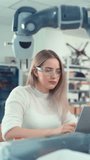 Automation Female Engineer Type at Laptop and Move Bionic Claw At the Factory. Modern Equipment and New Era in Computer Science Industry Concept. Vertical Video