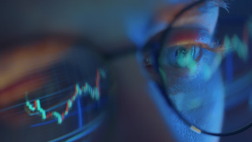 Trader wearing glasses is working on laptop computer. Screen with stock market charts and Bitcoin BTC or Ethereum ETH data analysis reflection. Broker trading online. Altcoins crypto currency trading - Powered by Shutterstock - Get 15% off with code: PIKWIZARD15