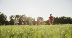 Children Joyfully Jumping in Sunlit Field - Happy Summer Slow Motion Video