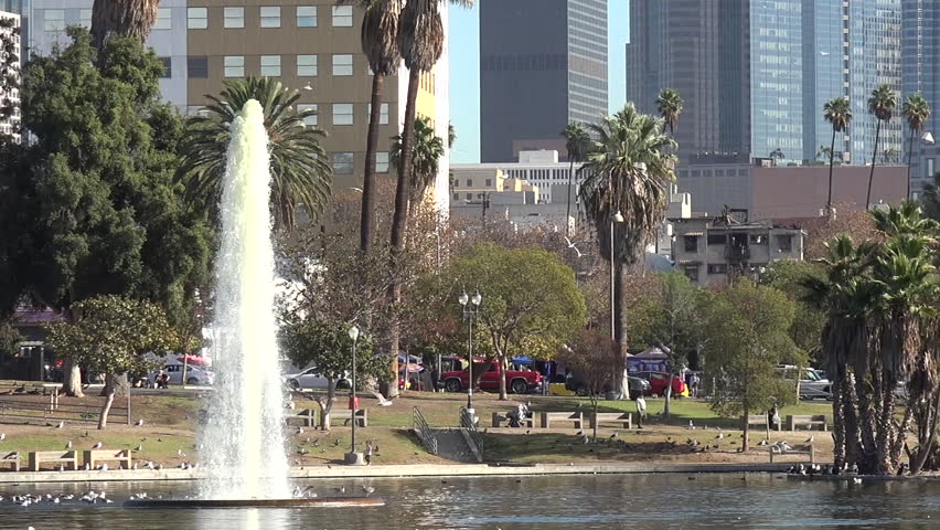 Pan across MacArthur Park to the fountain in the lake
