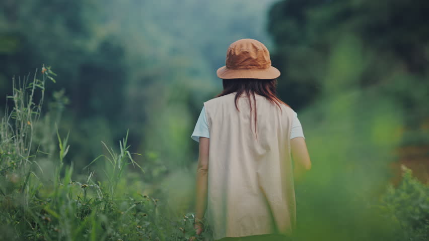 Happy young tourist female with camera taking photo of mountains and fog, Carefree woman in fields and stream, Rest on vacation holiday weekend