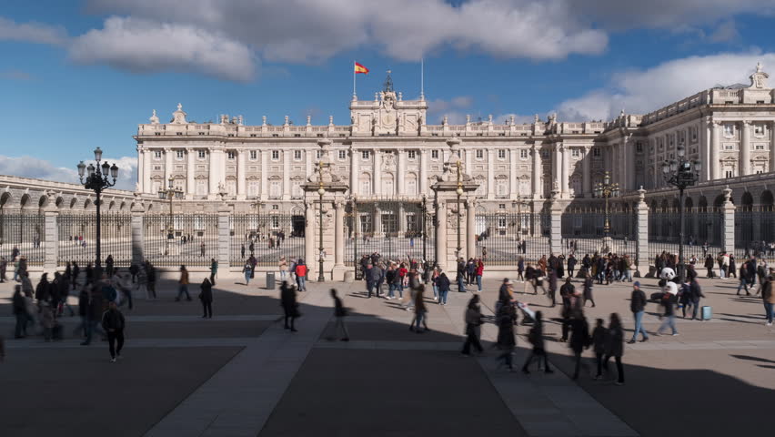 Madrid, Spain - February 24, 2024: Timelapse of the Royal Palace of Madrid with people walking past and looking around on bright day