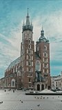 VERTICAL VIDEO, Time lapse, Tourists walk around the historical center of Krakow on a sunny day. Church of St. Mary, Main Market Square, Krakow, Poland