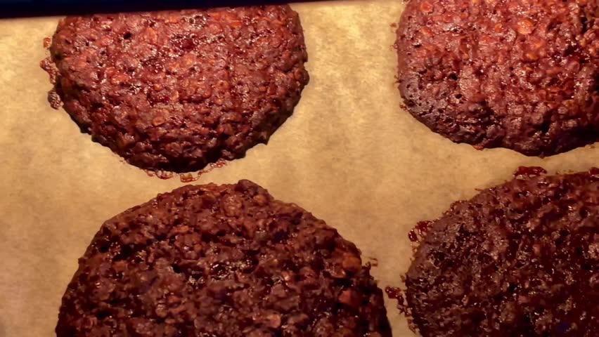 Baking sweet chocolate oat bisquits in the oven, homemade food recipe, slow motion video