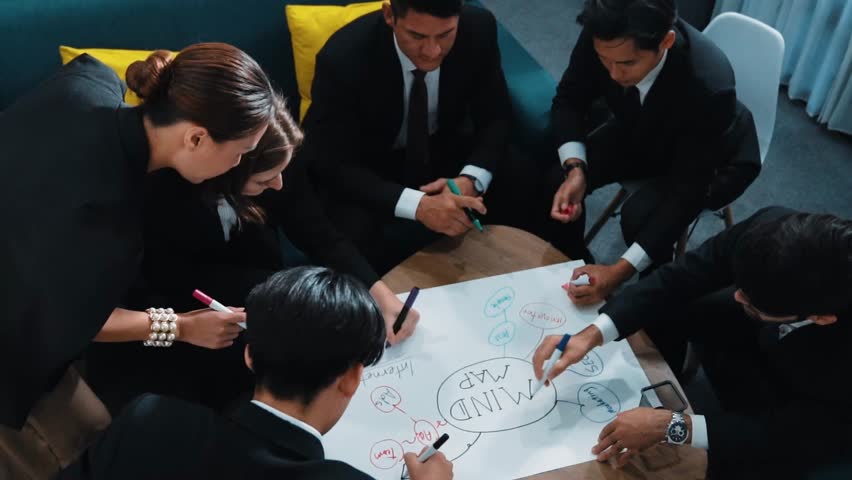 Top view of skilled diverse business people planning project by using mind map to brainstorm marketing idea. Smart start up team working together to draw mind map. Creative workplace. Directorate. Royalty-Free Stock Footage #3452575947