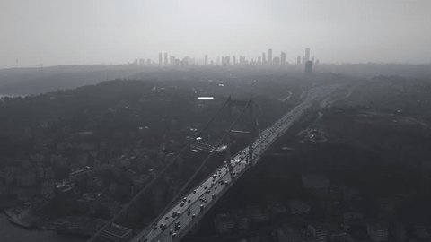 Witness the mesmerizing spectacle of the bridge linking to Asia amid skyscrapers during sunset, captured by drone footage. Traffic and cityscape portrayed in an awe-inspiring perspective.の動画素材