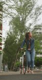 Vertical video of happy african american woman walking with bicycle in city. digital nomad on the go.