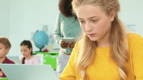 Horizontal shot. Class of preschool education. Little girl sitting at desk in front of laptop. African American teacher holding tablet and explaining new material. Private children school. - Powered by Shutterstock - Get 15% off with code: PIKWIZARD15