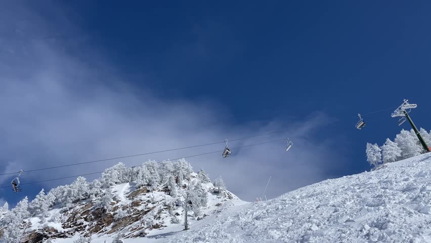 People riding chair lift in ski resort in Baqueira Beret