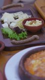 Vertical video. Delight in the vibrant tapestry of a traditional Turkish breakfast with this closeup stock video. From fresh vegetables to creamy cheese, warm bread, and local-style scrambled eggs