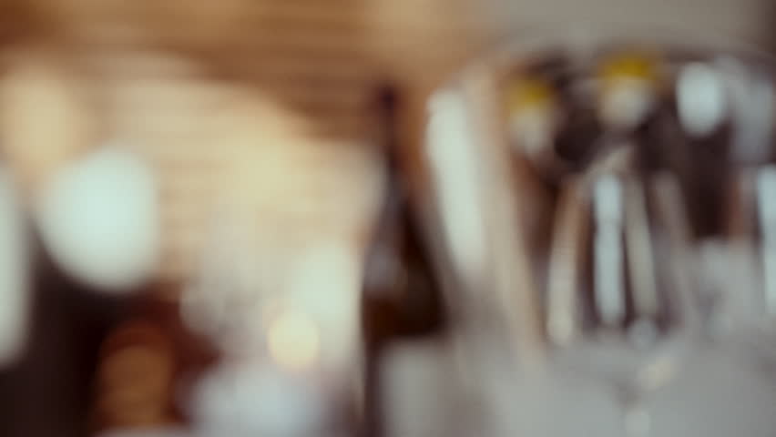 A close-up of red wine being poured from a bottle into a wine glass, the wine flowing smoothly into the glass, creating a slight splash as it fills up