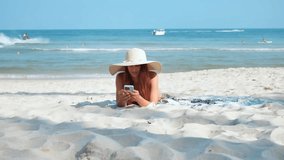 In bikini and sun hat woman lying on sandy beach using phone vacation. Vacation on beach sun's gentle warmth finds solace blending modern technology with seaside leisure woman vacation on beach. - Powered by Shutterstock - Get 15% off with code: PIKWIZARD15