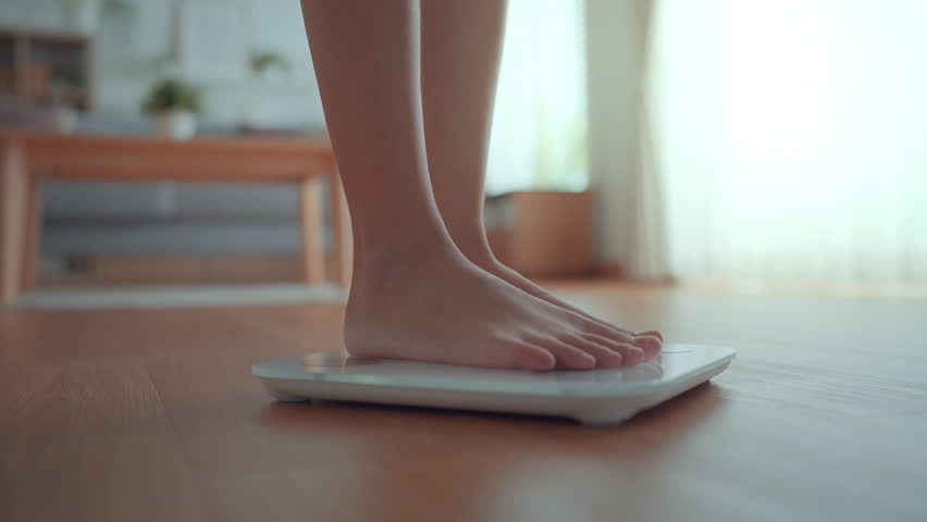 B roll - Woman Feet Standing Weighing Scales, Female Checking BMI Weight Loss. Barefoot Measuring Body Fat Overweight