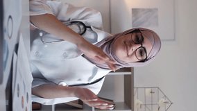 Vertical video. Supportive doctor. Treatment success. Healthcare celebration. Happy woman general practitioner specialist clapping hands at desk hospital workspace.