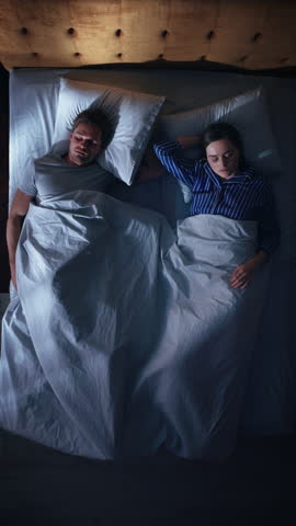 Top View Vertical Screen Apartment: Happy Young Couple Side Cuddling Together in the Bed Sleeping at Night. Beautiful Girlfriend and Handsome Boyfriend Sleeping Together. Family of two Embracing