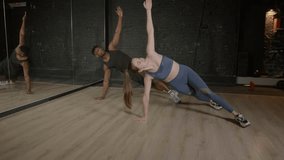 Active sporty fit lovely woman and muscular build African man exercising yoga side plank position on fitness mats, strengthening core muscles, improving posture and balance during indoor workout, - Powered by Shutterstock - Get 15% off with code: PIKWIZARD15