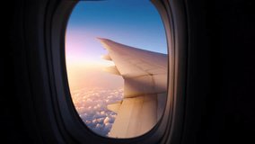 Airplane Window View Above the Clouds at Sunset. Looking through window aircraft during flight in wing at sunset.  - Powered by Shutterstock - Get 15% off with code: PIKWIZARD15