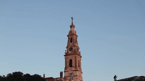 4K sunset video with Fatima Sanctuary in Portugal. Basilica of Our Lady of the Rosary filmed against rose blue sky before night. Religious travel to Portugal.