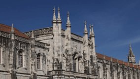 Jeronimos Monastery in Lisbon and Santa Maria de Belem Church landmark buildings in a 4K video during a sunny day with blue sky. Travel to Lisbon, Portugal.