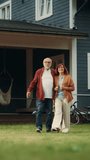 Vertical Screen: Healthy Senior Couple Walking Outdoors Their Residential Area Home, Embracing Each Other. Loving Adults, Talk, Have Fun, Point to the Distance and Enjoy Their Happy Retirement Life