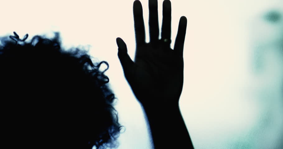 Woman trapped behind glass leaning hands feeling depressed and in desperation to get out. Mental illness concept of person suffering from despair and loneliness