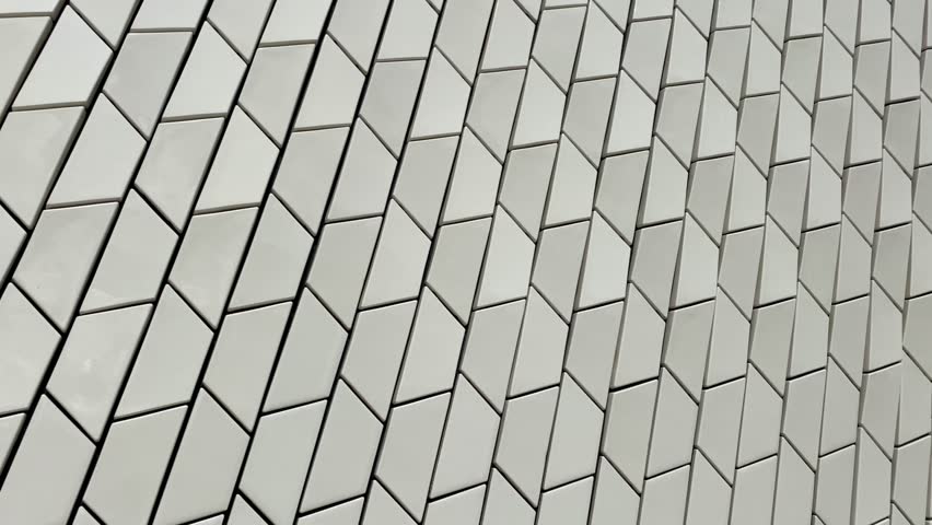 view of a wall with beige tiles and a blue sky with white clouds
