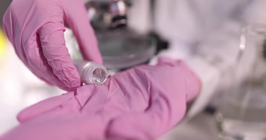 Scientist pours mercury or liquid metal from bottle. Chemical research galia concept