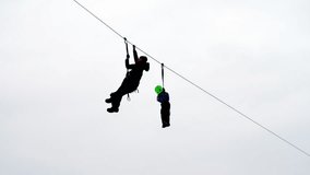 Zip-line in winter. Mother and child rest together at adventure rope park and enjoy excited zip-lining against grey cloudy sky - Powered by Shutterstock - Get 15% off with code: PIKWIZARD15