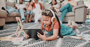 Girl, tablet and headphones in living room for education, video and online entertainment on carpet. Kid, technology and relax on floor with audio support for development, knowledge and elearning
