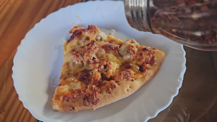 Spicy Symphony of Chili Flakes Dance on a Golden Pizza Slice