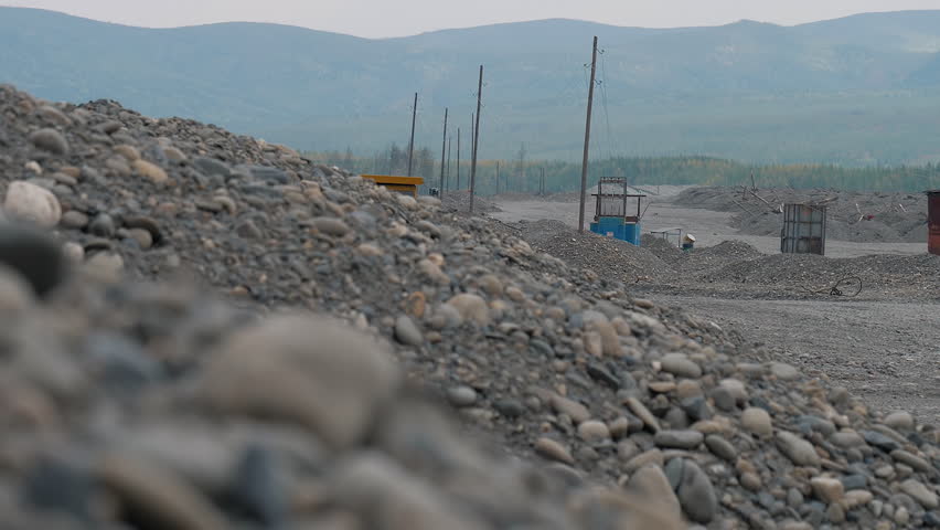 Mining Industry Dump Truck Machine Drives Near Heaps Of Rock. Mining Industry Machine Transports Mined Minerals At Quarry. Industrial Machine Loaded With Mined Stones. Vehicle. Equipment