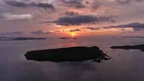 Panorama of sunrise on tropical sea. Aerial view amazing light through sky in sunset over the edge of mountain islands. Colorful sky background. Day to night scenery pink light shine through on sky