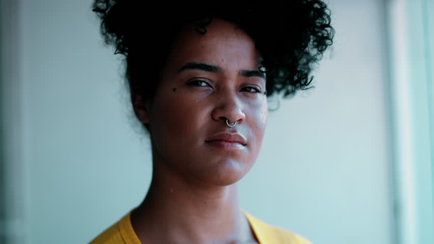 One young South American black woman of African descent smiling at camera portrait. 20s female person with friendly demeanor