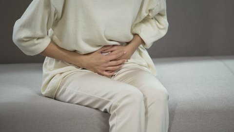 Young woman suffering from strong menstrual or stomach ache, gynecology problems
