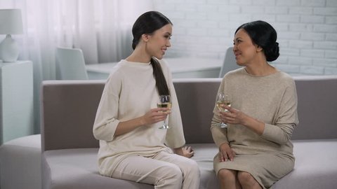 Two happy asian women drinking white wine, celebration of victory, partnership