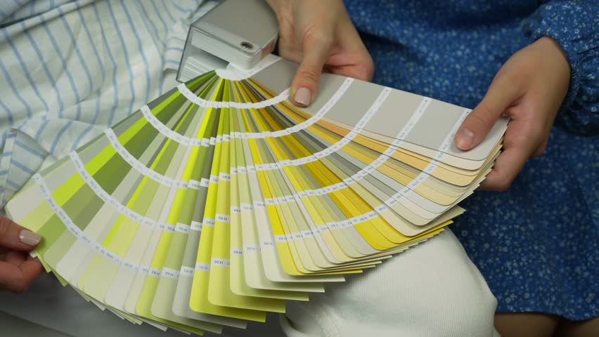 Two young clients choosing paint color from palette for wall paint. Close up palette Royalty-Free Stock Footage #3453379367