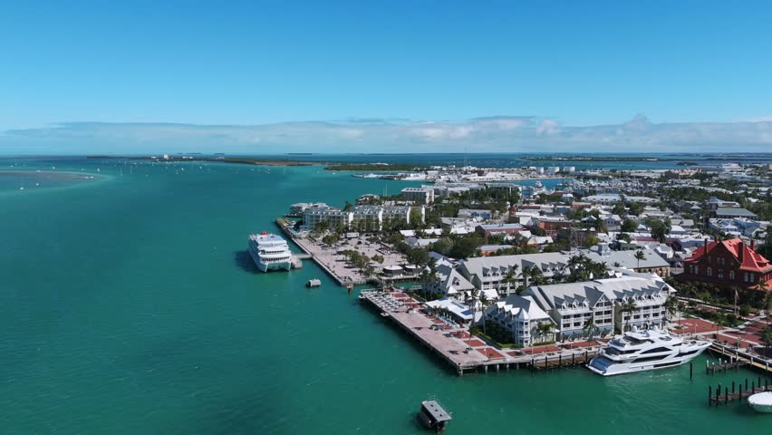 Aerial view of Key West, Southernmost Point of Continental USA. Beautiful turquoise waters surrounding land and buildings with varied architecture. Yachts docked near shore