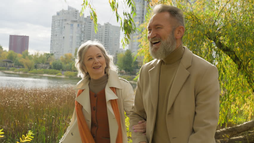 Happy family Caucasian married couple elderly partners smiling woman man walking strolling together in city park carefree husband wife retired 60s old female male grandparents going outdoors nature Royalty-Free Stock Footage #3453442023