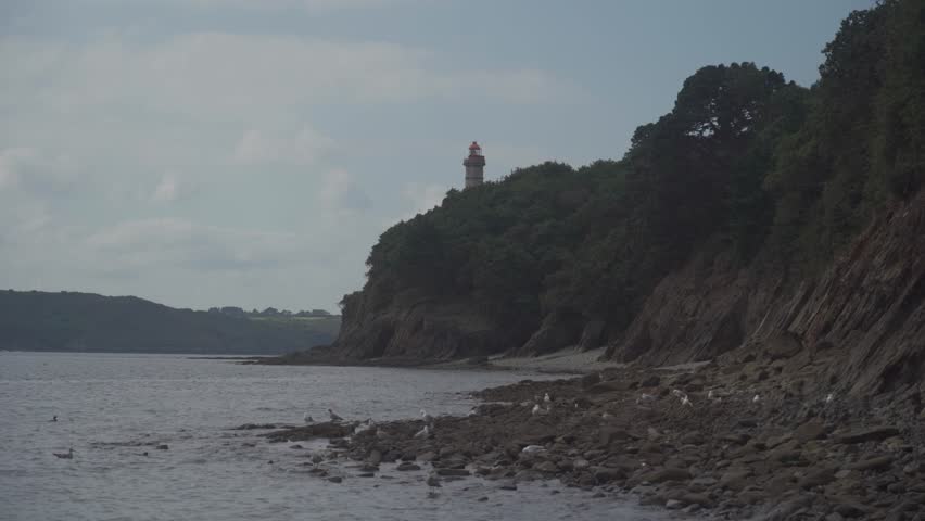 Phare Du Portzic lighthouse and the rocky shore of the ocean in the French city of Brest. View of the Phare du petit minou in Plouzane, Brittany, France. Portic Lighthouse.