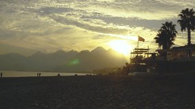 
Sunset on Konyalti beach. Sunset over Antalya. The sun is setting over the mountains. The sun is reflected in the sea. Beautiful sunset sky. Colors of the sky.