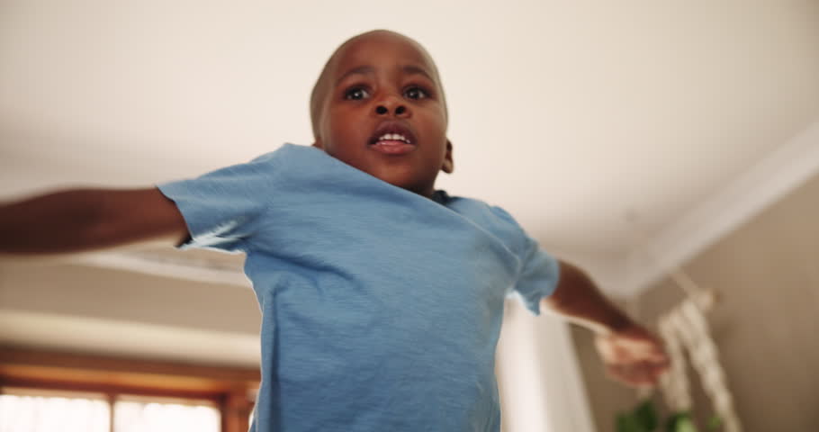 Jump, fun and kid in a house happy, playing and wake up with morning energy, games or bounce at home. Joy, moving and African boy with freedom, celebration or excited for vacation, holiday or weekend