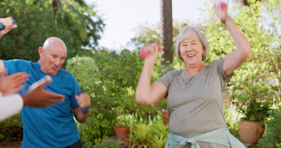 Senior care, old people and caregiver dancing, exercise and physiotherapy in garden for rehabilitation. Energy, happy and weightlifting with dumbbells for muscle training outdoor at nursing home