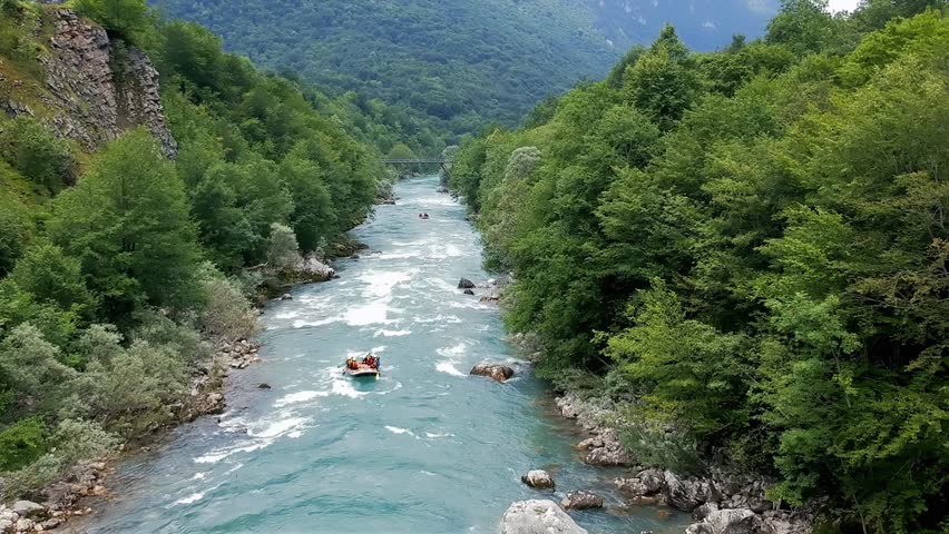 Whitewater Rafting - Aerial View. People in Inflatable Rafts Paddling Through River Rapids. Active Vacations. Picturesque Canyon with High Mountains, Forest and Mountain River.