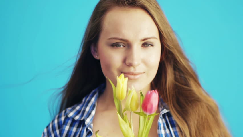 young woman sniffing tulips at studio