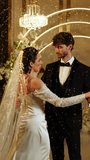 The bride and groom dance the first dance in the falling snow. Wedding day. Concept of the first wedding dance. Vertical video. 4k