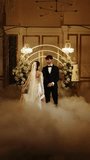 The bride and groom dance the first dance in the falling snow. Wedding day. Concept of the first wedding dance. Vertical video. 4k