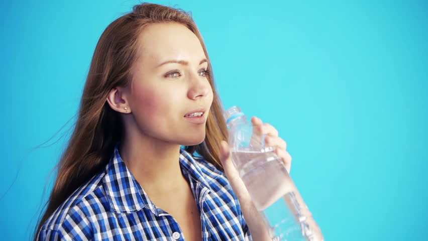 pretty woman drinking water from bottle and smiling